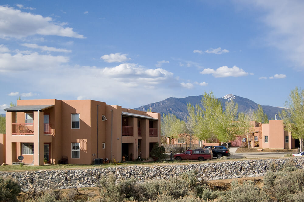 Two-story adobe-style building at Loma Parda with balconies facing the mountains outside Taos